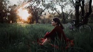 girl-sitting-on-grass-field-looking-so-far-vintage-tone