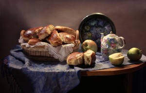 still-life-basket-toast-apple-teapot-tray-shawl-on-wooden-table