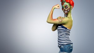 halloween make-up skull beautiful girl with green skin over grey background